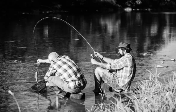 Fly fish hobby of men. retirement fishery. happy fishermen friendship. retired father and mature bearded son. big game fishing. relax on nature. Two male friends fishing together. It is a big fish — Stock Photo, Image