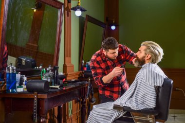 Bıyıklı ve sakallı hippi. Adam yeni saç stili istiyor. Erkek güzellik ve moda. Berber dükkanında olgun bir adam. Kuafördeki sakallı adam. Erkek müşterisi olan profesyonel berber. Ateş gibi saçlar.