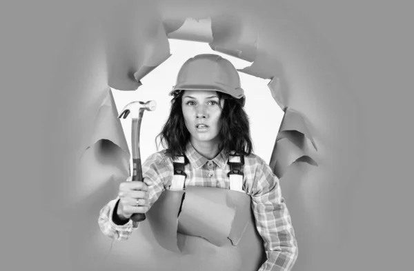 Byggherreassistent reparera och fixa. Kvinnlig arbetare i uniform. Glada kvinna bär skyddshjälm. Flicksnickare använder hammare. glad vacker dam ingenjör — Stockfoto