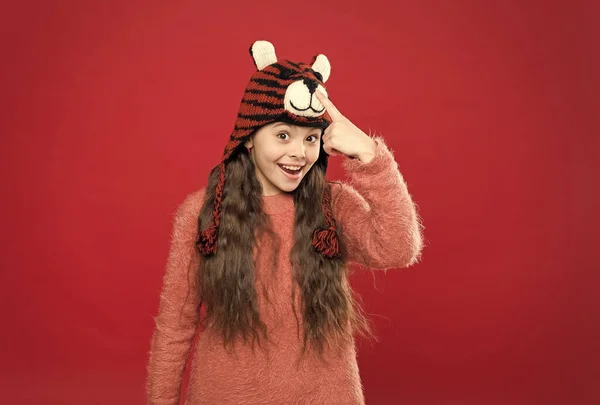 Усміхнена дівчина-підліток в затишному теплому одязі демонструє зимовий капелюх, в'язання — стокове фото
