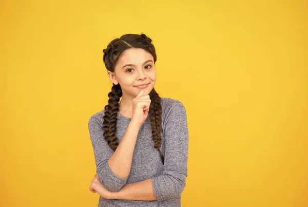 Menina criança sorridente com cabelo trançado elegante no fundo amarelo, beleza — Fotografia de Stock