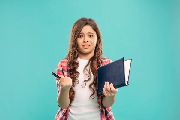 Verward kind houden notebook op blauwe achtergrond, jeugd — Stockfoto