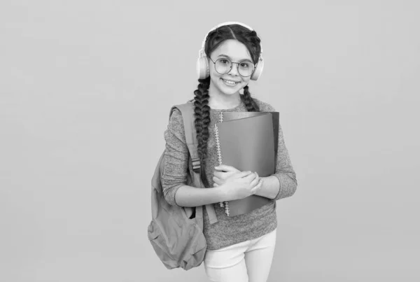 Menina estudante moderno com mochila e material escolar fundo amarelo, conceito homeschooling — Fotografia de Stock