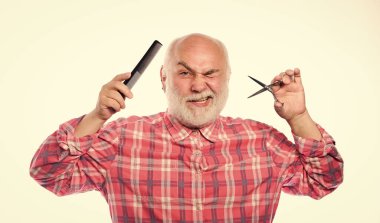 Berber keskin makasla çalışır. Berber dükkanı konsepti. Sakallı yakışıklı kuaför, sakal şekillendirme aleti kullanıyor. Erkek tıraşı. Saç kes. Berber profesyonel ekipman kullanır. Kuaför servisi