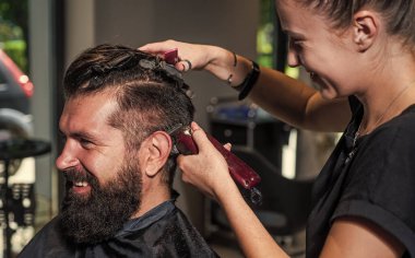 Berber dükkanında yakışıklı bir adamın saçını kesen çekici berber, kuaför aletleri.