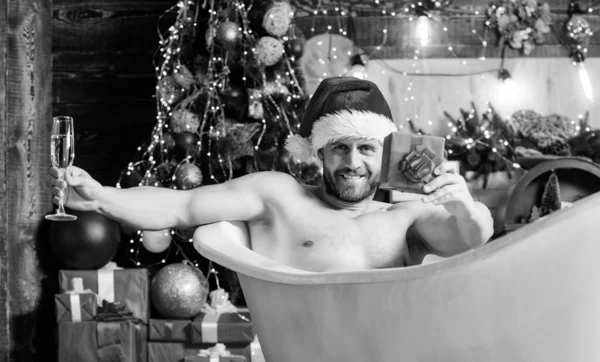 Magabiztos és szexi. Karácsonyi ajándék. Karácsonyi fürdő. Boldog újévi ajándékot. erotikus vágy. Érezd a vágyat. macho pezsgőt iszik buli után. szexi érett férfi fürdő. téli szünet. izmos férfi pihenjen fürdőkád — Stock Fotó