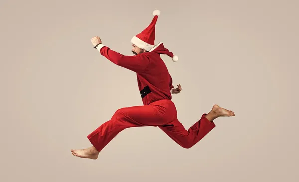 Ünnepeljünk! Boldog karácsonyt! Karácsonyi buli. Boldog szakállas hipszter vörös ünnepi manó jelmezt visel. érett Mikulás ugrás. vicces téli ünnepség. Nyugodtan. boldog új évet 2021-ben — Stock Fotó