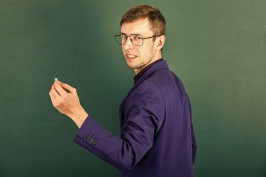 Üniversite öğretmeni tahtaya yazı yazar. Kolejde öğrenci eğitimi. Modern eğitim konsepti. Genç ama yetenekli bir iş adamı. Tipik bir ofis çalışanı. Adam gözlük ve ceket giyiyor. Okula geri dön.