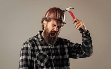 Çekiçli üniformalı erkek işçi. Çalışan aletleri olan bir inşaatçı. Acımasız olgun hippi.