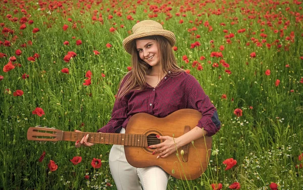 Jeune femme dans le champ de pavot avec guitare, musique — Photo