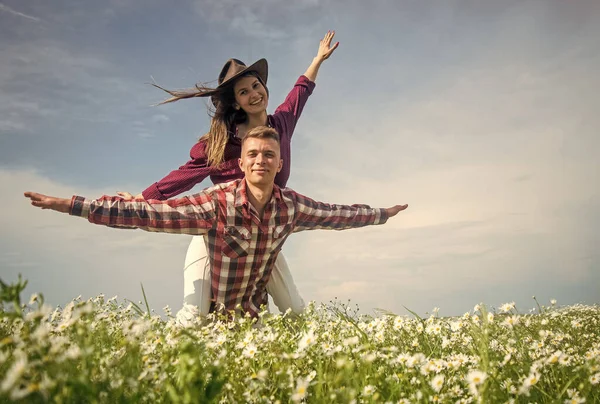 Couple heureux amoureux de l'homme et de la femme dans le champ de fleurs de camomille d'été, s'amusant — Photo