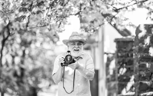 Walking his favorite street. Senior man hold camera. Naturalist concept. Spring sakura bloom. Travel and tourism. Photographer in garden. Capturing spring beauty. Spring holidays. Enjoying free time — Stock Photo, Image