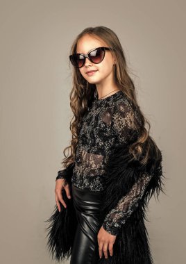 Kıvırcık saçlı, gözlüklü neşeli çocuk.