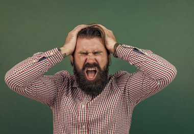 Sakallı vahşi adamın başı ağrıyor. gayri resmi eğitim. Erkek öğrenci ders sırasında sınıfta oturur. Sınavı geç. Hasta ve yorgun. Konuyu öğrenmek. Okula dönüyorum. Mutlu öğretmenler günü