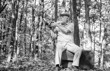 Dışarıdaki kameraman. Profesyonel fotoğrafçı. Emeklilik hobisi. Retro fotoğrafçı. Manuel ayarlarda kullanılır. Yaşlı adam doğada ateş eder. Manzara ve doğa fotoğrafı çekimi. Eski fotoğrafçı.