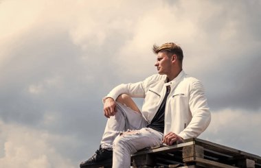 Beyaz şehir kıyafetleri içinde kendine güveni olan genç bir adam açık havada, moda.