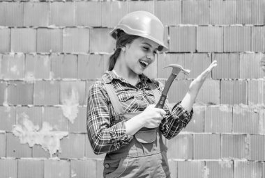 Çocukların yaratıcılığı. İşçi Bayramı 1 Mayıs 'ta. Sert şapkalı küçük kız çekiç tutuyor. Gelmiş geçmiş en iyi tamirci. Çekiç kullanmayı öğrenmek. Çekiç sesi. O iyi bir asistan. Marangoz çekici olan çocuk mühendis.