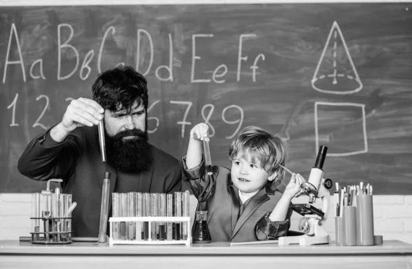 Investigación y desarrollo de laboratorio. La innovación es la clave. De vuelta a la escuela. padre e hijo en la escuela. campamento de ciencias. Experimento químico con vasos de precipitados. Profesor con un niño pequeño. Educación escolar — Foto de Stock