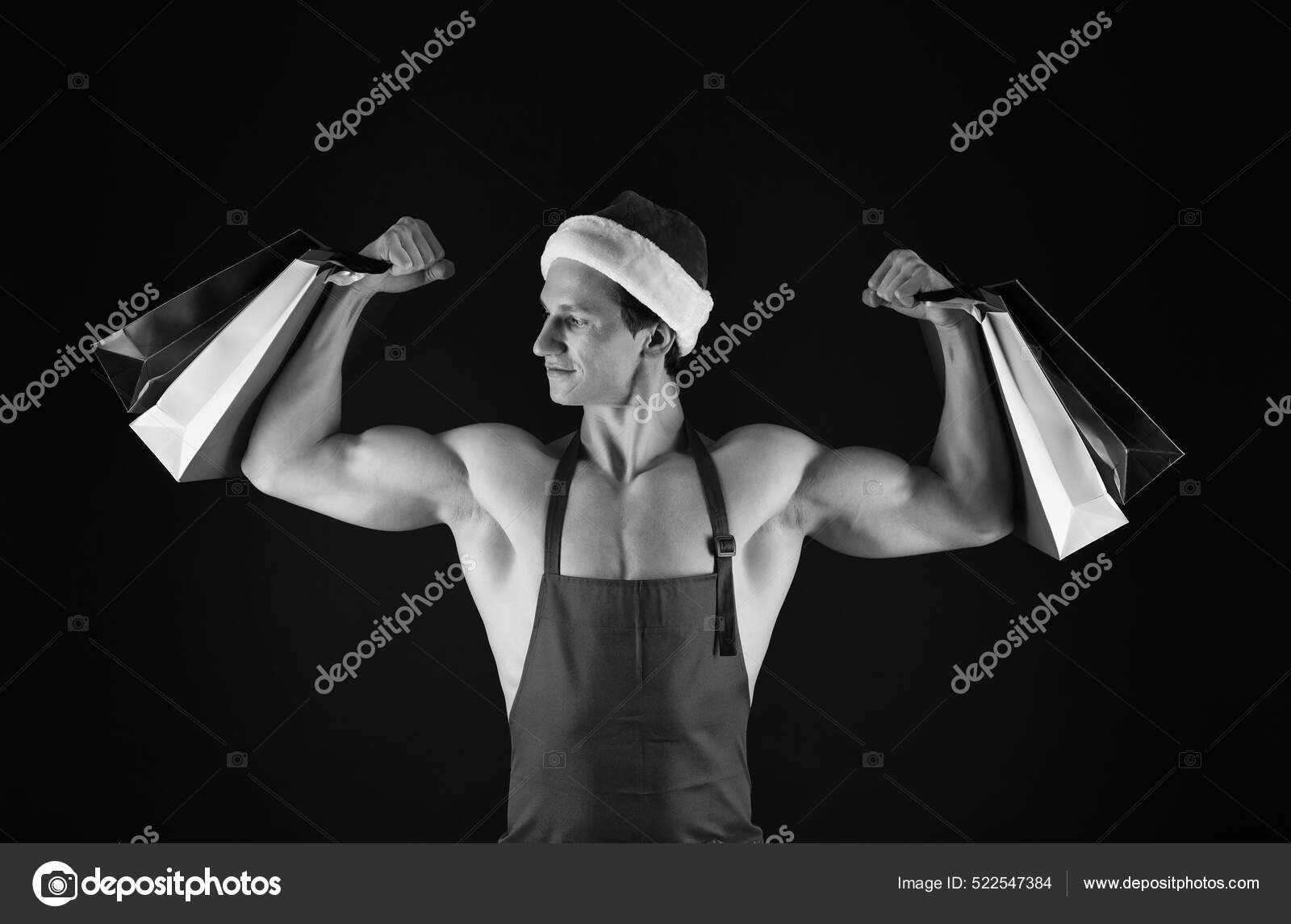 Fit santa claus hold shopping bags flexing muscular arms biceps