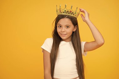 Tam oturdu. Lüks ve başarı. Bencil küçük kız altın taç takıyor. Küçük prenses çocuk. Şampiyon gibi hissediyorum. Mutlu çocukluk. İyi motivasyon konsepti. O büyük patron. Ödülünden gurur duyuyor.