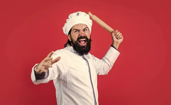 Хлопець шеф-кухар в капелюсі з бородою і вусами на червоному тлі, сердитий шеф-кухар — стокове фото