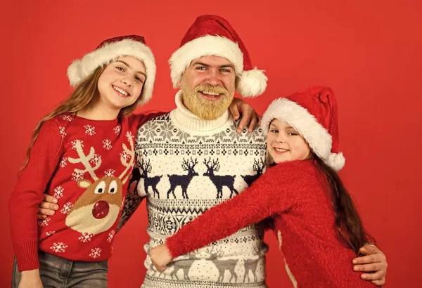 Καλές γιορτές. Τα μικρά κορίτσια αγαπούν τον πατέρα τους. Ο μπαμπάς αγκαλιάζει κόρες. γενειοφόρος Άγιος Βασίλης με παιδιά. πλεκτή μόδα για όλους. ζεστό και ζεστό χειμώνα. Έρχεται η νέα χρονιά. Ευτυχισμένη οικογένεια γιορτάζουν Χριστούγεννα — Φωτογραφία Αρχείου