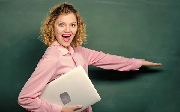 学校教育の概念。学校の講師がトピックを説明。女性のかわいい先生は黒板の近くにノートパソコンスタンドを保持します。教師用ソフトウェア。近代教育。学校に戻る。情報学を教える — ストック写真
