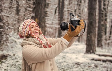 İlham özel bir şey yaratır. Gününü dışarıda geçir. Karlı doğada klasik kamerası olan bir kız. Seyahat konsepti. Kışın yakalanması. Çarpıcı kış fotoğrafları çek. Kış hobisi. Kadın fotoğrafçı