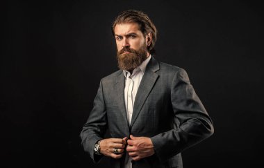 Sakallı adam gri takım elbise giyer. Şirket tarzı, moda stilisti.