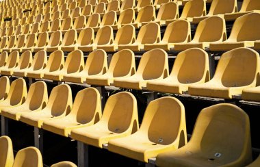 Seyirciler için sandalye. Kültürel çevre kavramı. renk ve simetri. Boş koltuklar. Modern stadyum. Sarı Tribünler. Tribün 'ün spor stadyumundaki koltukları. Açık hava sahası boş. fan konsepti