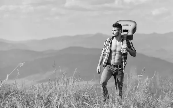 Bate que amas. feliz e livre. Homem cowboy com tronco musculoso nu. guitarrista acústico. música country. homem sexy com guitarra em camisa quadriculada. moda hipster. camping ocidental e caminhadas — Fotografia de Stock