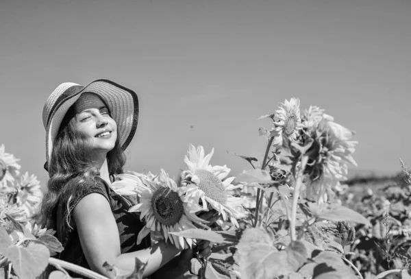 Beleza da natureza de verão. menina no campo de girassol. flor amarela de girassol. infância feliz. menina bonita usar chapéu de verão palha no campo. Um miúdo bonito com flores. Confiança em mente — Fotografia de Stock