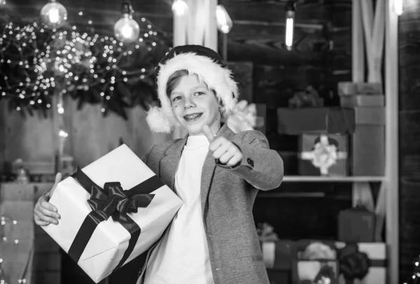 Всего наилучшего. Зимние праздники. Ребенок доволен подарком на Рождество. Мальчик празднует Рождество открытой подарочной коробкой. Санта принес ему подарок. Зимние покупки. Рождественский дух. Распаковка рождественского подарка — стоковое фото