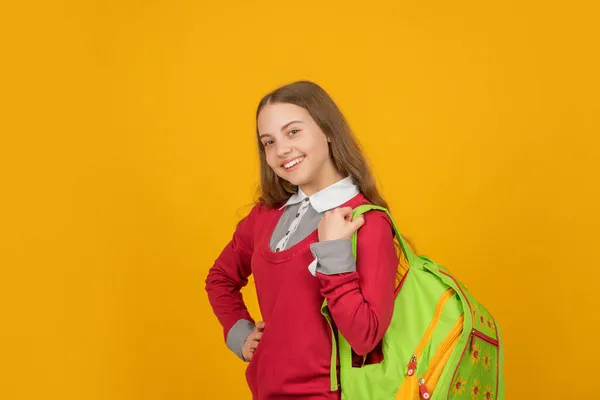 Šťastný dítě se školním batohem na žlutém pozadí, škola — Stock fotografie