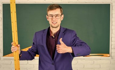 Matematik ve insanlar kavramı. Tahtadaki adam. Okula dönüyorum. Bilgiye doğru. Geometri favori konusu. Erkek öğretmen matematik cetvelini tutuyor. Eğitim ve okul konsepti. kök okul disiplinleri