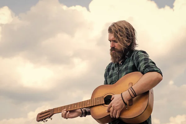 Tipo con barba y bigote tocar la guitarra. hombre barbudo con camisa a cuadros cantar canción. músico intérprete de música. instrumento de cuerda musical. guitarrista masculino carismático maduro — Foto de Stock