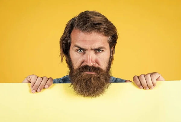 Serious bearded man. barbershop and hairdresser. We can help to community. brutal caucasian hipster hold paper shit, copy space. human emotions. unshaven guy with groomed long hair — Stock Photo, Image