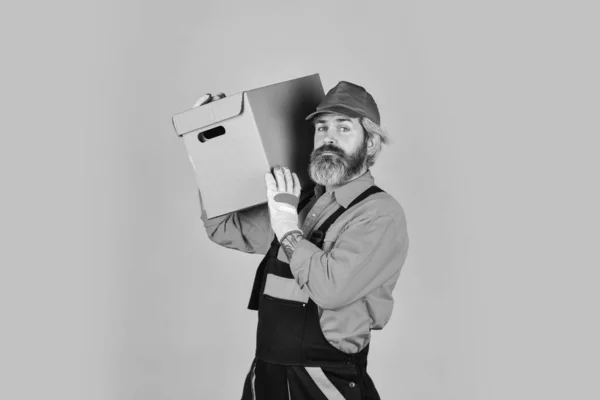 Wie man besser lebt. Kartons - Umzug in ein neues Haus. Kauf einer neuen Wohnung oder Reparatur eines Zimmers. Mann im Anzug beim Packen von Kartons. Umzug in neue Wohnung. Bartlader in Uniform — Stockfoto