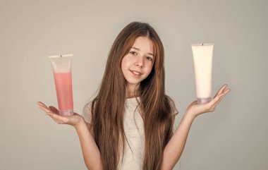 Uzun düz saçlı neşeli kız saç kremi şampuan ya da jöle şişesi, vücut bakımı