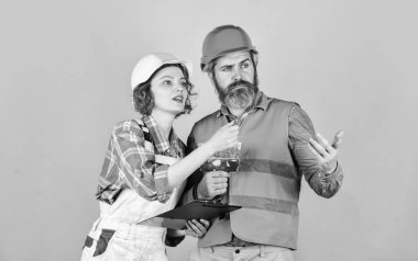 Sıva işe yarıyor. Çift evraklara bakıyor. Kadın ve erkek güvenlik kaskı. Çift planlama yenileme dairesini değiştirir. Yenileme konsepti. Plana göre. Müteahhitle tadilatı tartışıyoruz.