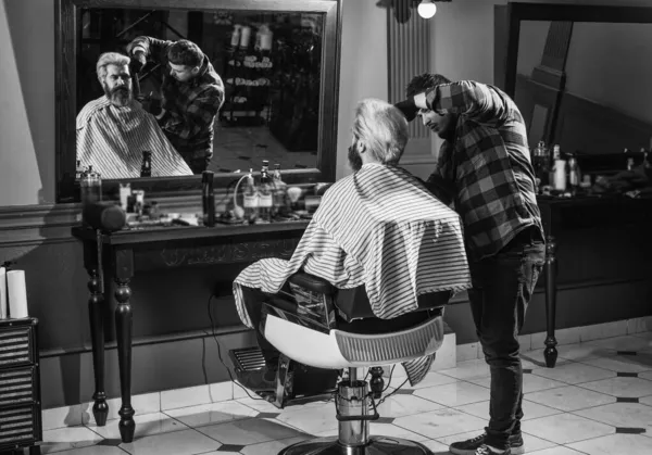 Onun mükemmel tarzı. Adam yeni saç stili istiyor. Erkek güzellik ve moda. Berber dükkanında olgun bir adam. Kuafördeki vahşi sakallı adam. Berber ve erkek müşteri. Bıyıklı ve sakallı hippi.