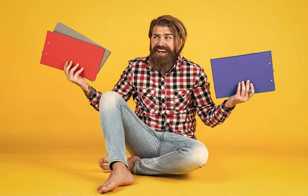 Hipster maduro caucásico con peinado de moda en camisa a cuadros haciendo notas en documentos de papel de carpeta, documentación — Foto de Stock