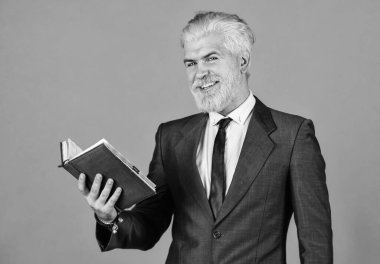 Olgun bir adam sakal ve saç boyadı. Kitap okuyorum. Notlarını kontrol et. Günlük program. Erkek profesyonel öğretmen. Berber dükkanından sonra. İşletme okulu eğitimi. Mutlu iş adamı defteri tutar.