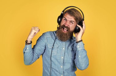 Tutkunu yaşa. Kulaklıklı erkek müzik dinler. Kitap ve el kazanma konsepti. İnternet eğitimi. Online iş kursu. En sevdiği şarkı. Neşeli adam modern kulaklık takıyor.