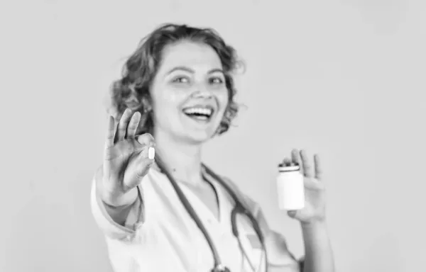 O médico está a oferecer comprimidos. introduzindo as propriedades do analgésico. O doutor feminino dá o jarro de pílulas ao paciente. Médico confiante segurando frasco pílula. medicação útil. foco seletivo — Fotografia de Stock