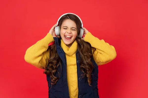 Happy shouting teen girl in hat and earphones. modern life in childhood. child listen music — Stock Photo, Image