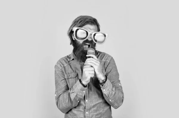 Καυκάσιος hipster με γενειάδα και κομψά μαλλιά σε arty γυαλιά με μικρόφωνο, μουσική — Φωτογραφία Αρχείου