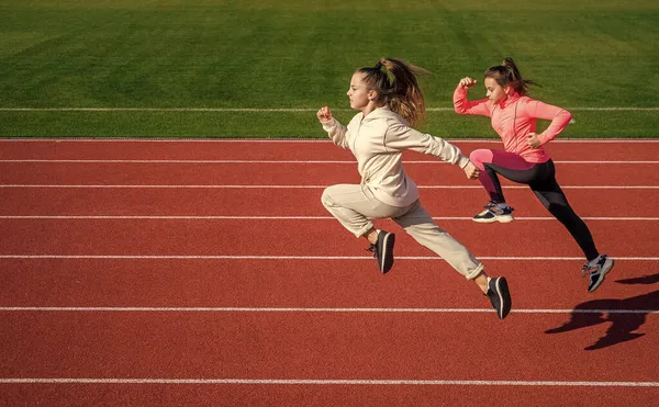 Dayanıklılık. Genç kızlar maraton koşar. Yarış koşucusu. Stadyum salonunda sprinter ısınıyor. Çocuklar beden eğitimi dersinde eğitim görüyorlar. Hız ve hareket. Sadece uçuyorum. — Stok fotoğraf