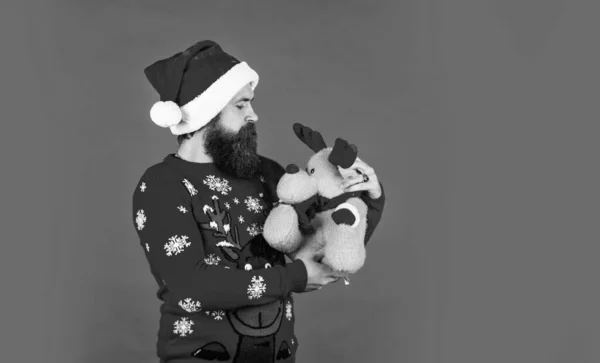 Çocuklar için hediyeler. Sevgili Noel Baba. Sakallı adam ren geyiği oyuncağı. Hipster adam Noel hediyesini saklar. Mutlu adam neşeli ruh hali. Yumuşak geyik. Mutlu yıllar. Noel Baba 'ya yardım ediyorum. Noel 'in sembolü. Noel arifesi — Stok fotoğraf