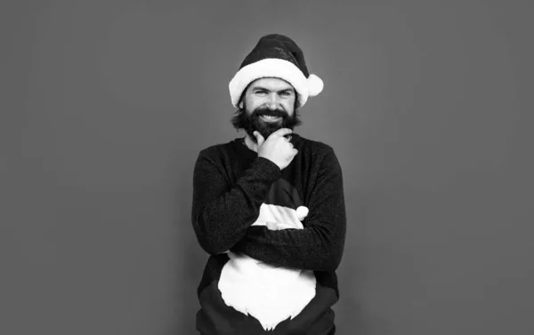 Feliz año nuevo. Feliz navidad. hombre barbudo alegre en sombrero de santa claus y suéter. brutal hipster celebrar la fiesta de Navidad. preparativos de vacaciones de invierno. regalo y regalo venta de compras —  Fotos de Stock